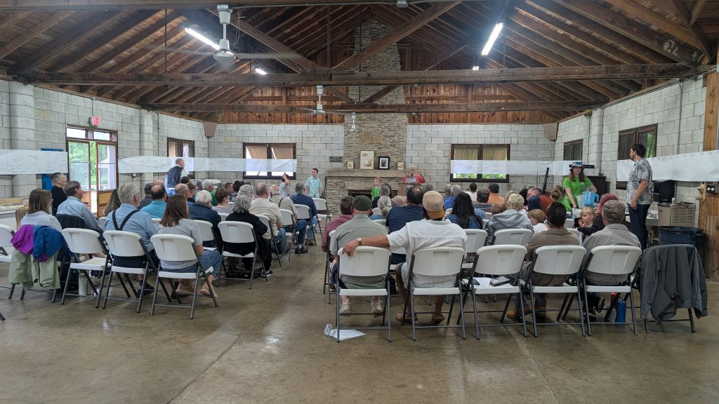 Photo of participants at QK 75th Anniversary celebration, Nancy McCormick speaking.